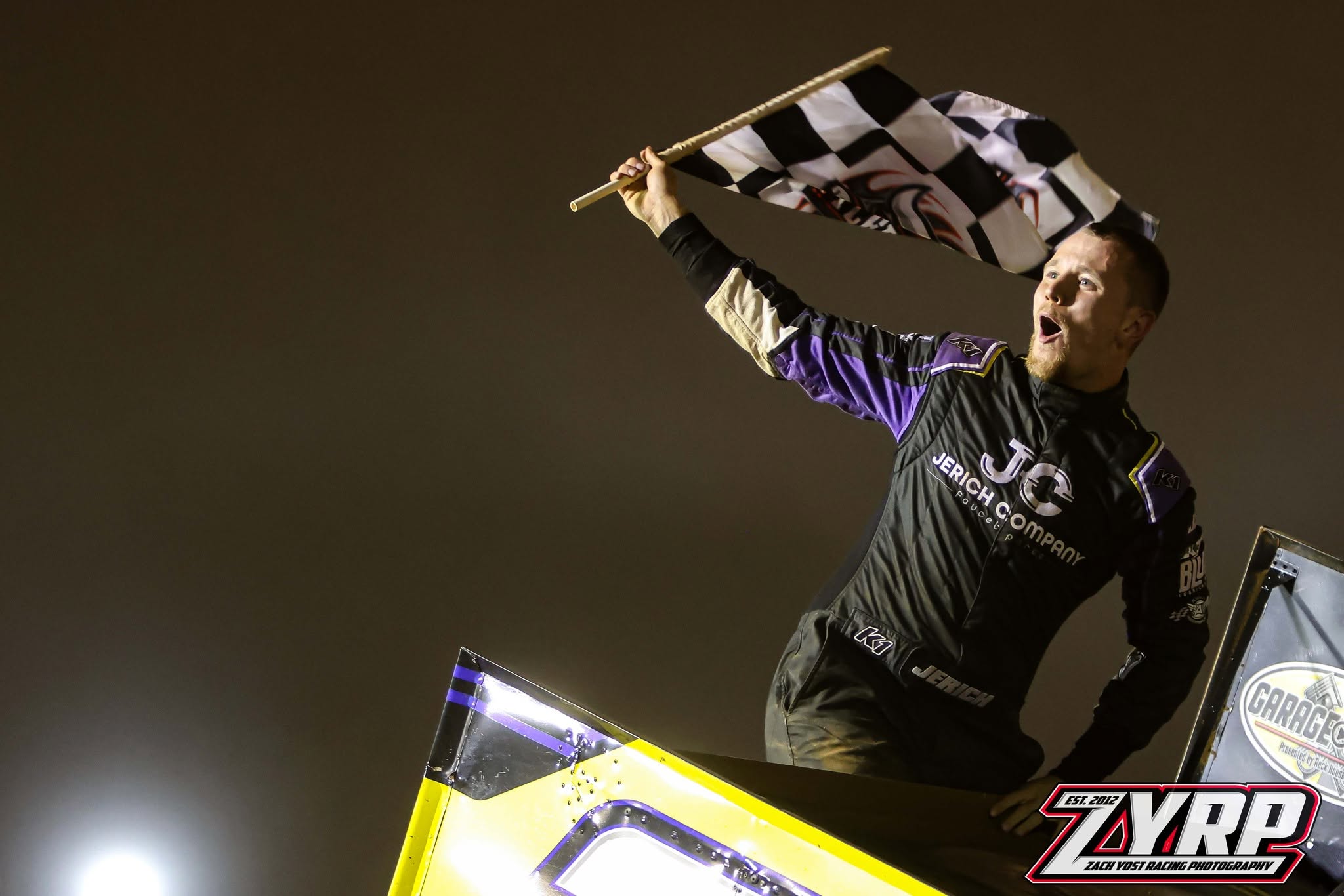 John Jerich waving the checkered flag from the car after a feature win